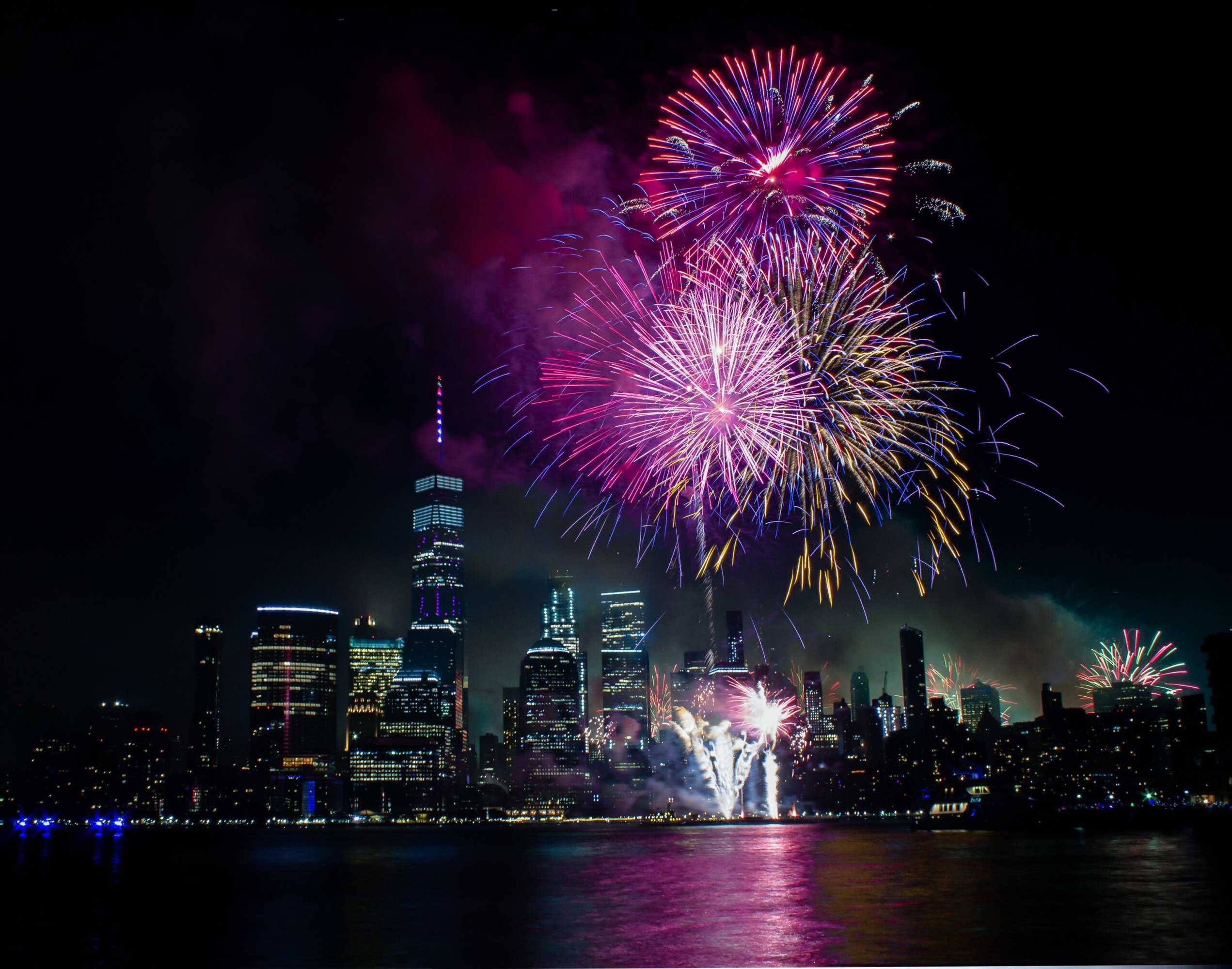 Fireworks happening over the skyline of New York City.