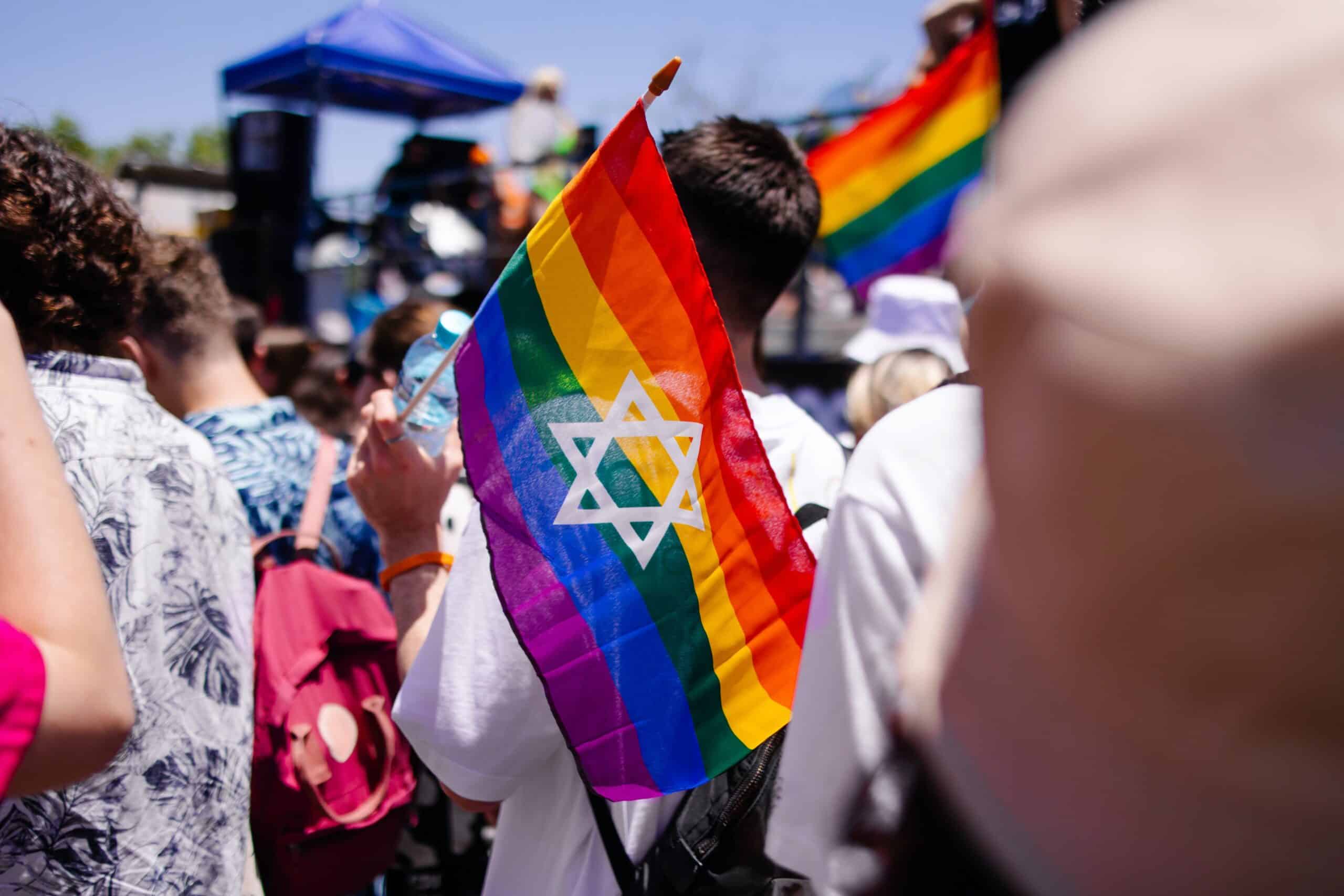 Man holding a gay Pride Israeli flag during Tel Aviv Pride Parade. 