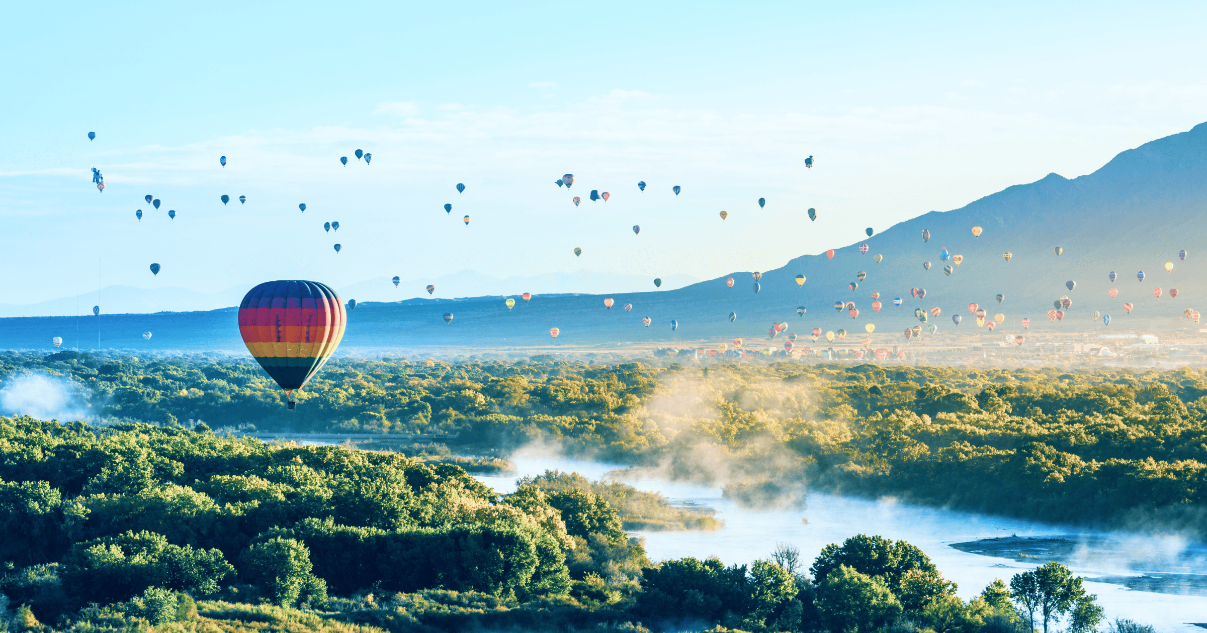 Hot air balloons floating over a valley in Albuquerque