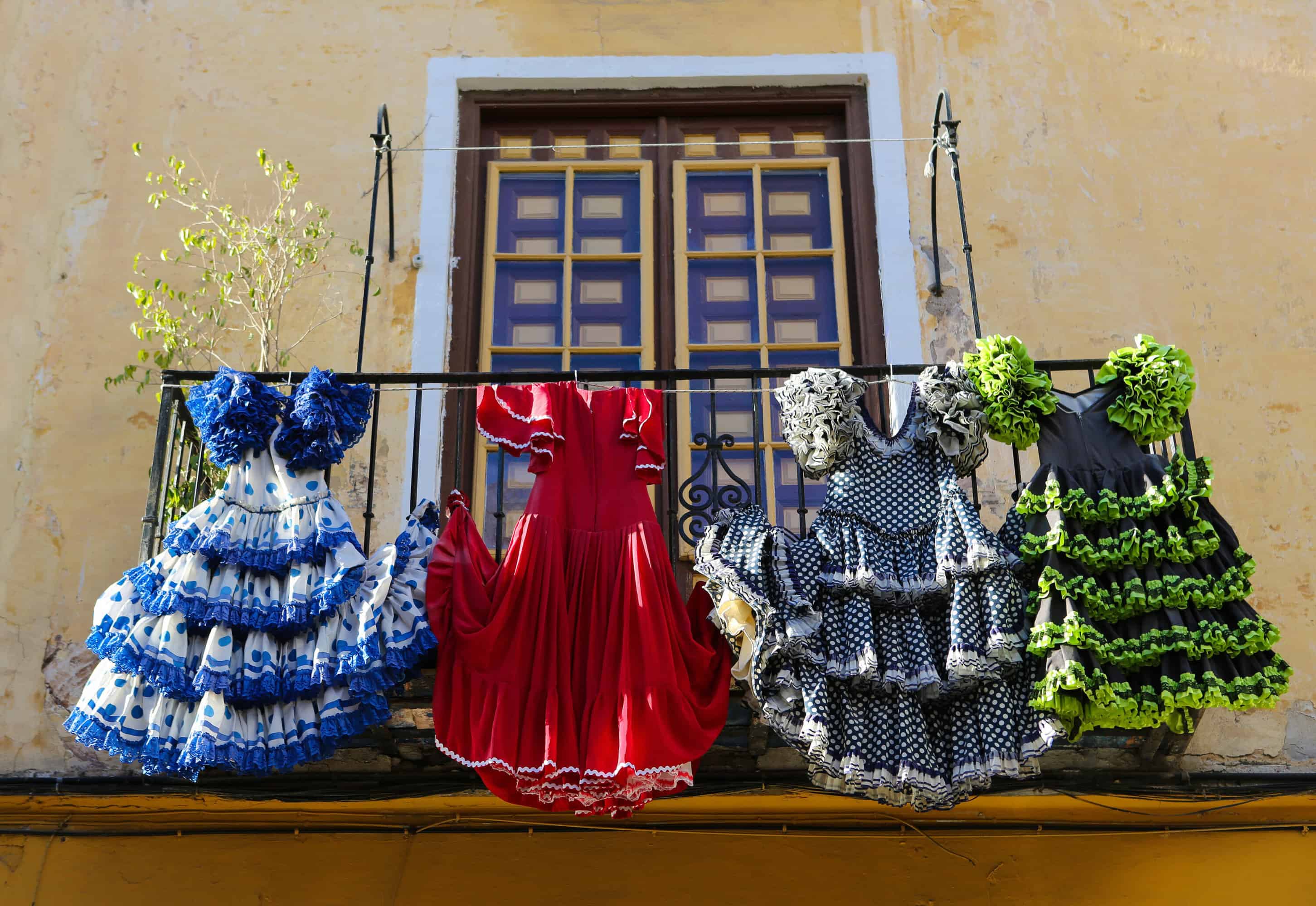 Flamenco dresses hanging from a balcony.