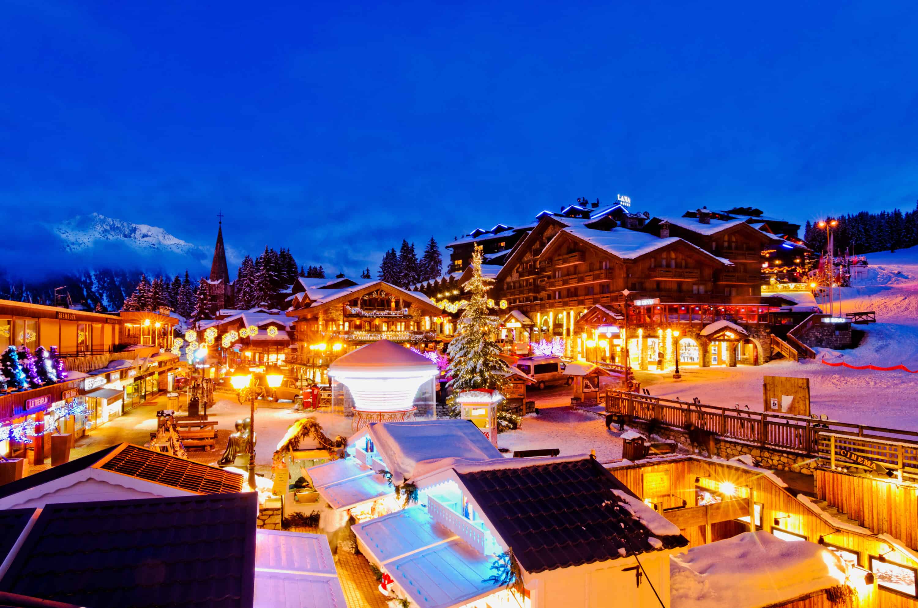The town of Courchevel lit up at night with mountains in the background.