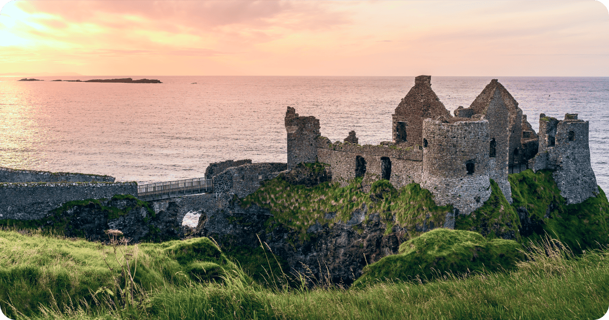 Ruined medieval Dunluce Castle on the cliff at amazing sunset