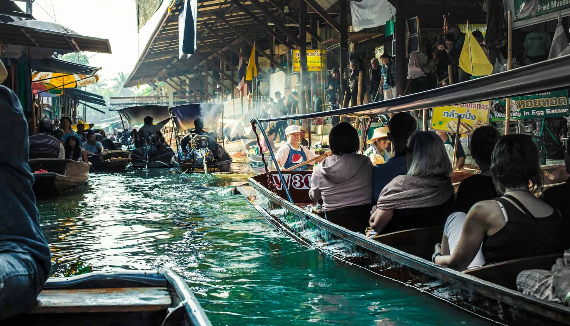 People in boats going through the Floating Market in Thailand.